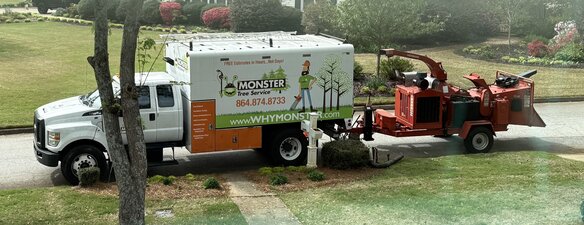 Monster Tree Service of Greenville County branded service truck and wood chipper parked at a residential property in Greenville County, SCMonster Tree Service of Greenville County branded service truck and wood chipper parked at a home